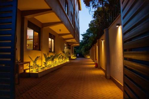 une allée vide entre deux bâtiments la nuit dans l'établissement Blueberries Hotel, à Entebbe