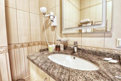 a bathroom with a sink and a mirror at Ukraine Hotel in Kyiv