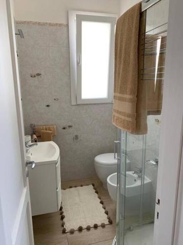a bathroom with a toilet and a sink and a mirror at Le Giraffe ( n.CIS LE07503191000035725) in Rivabella
