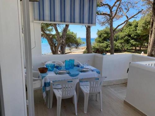 a white table with chairs and a table with a view of the ocean at Le Giraffe ( n.CIS LE07503191000035725) in Rivabella