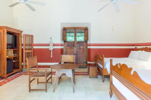 a bedroom with a bed and a table and a bed at Hacienda San Jose Cholul in Tixkokob