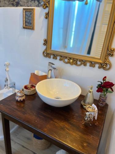 a bathroom with a sink and a mirror on a table at La Casina di Sandro in Nocera Umbra