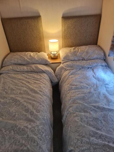 two beds sitting next to each other in a room at Beautiful 3 bedroom holiday home Amazing views in Gisburn