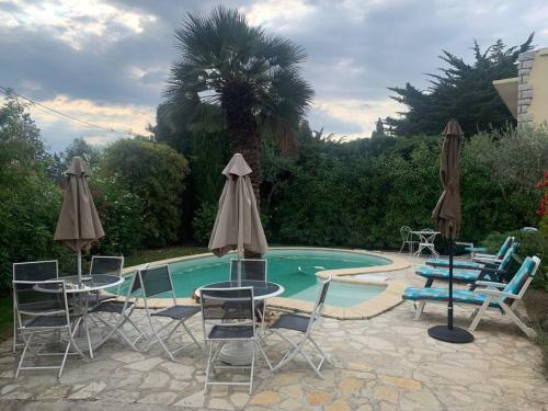 - une piscine avec des chaises, des tables et des parasols à côté dans l'établissement Studio dans villa proche de la plage, à Sète