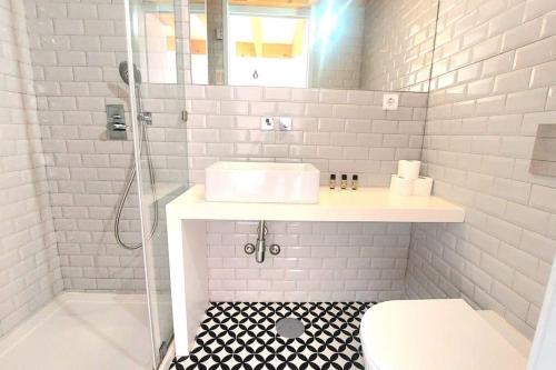 uma casa de banho branca com um lavatório e um chuveiro em Oporto City View - Wow Duplex no Porto