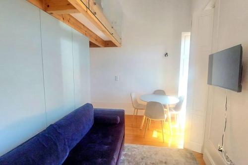 - un salon avec un canapé bleu et une table dans l'établissement Oporto City View - Wow Duplex, à Porto