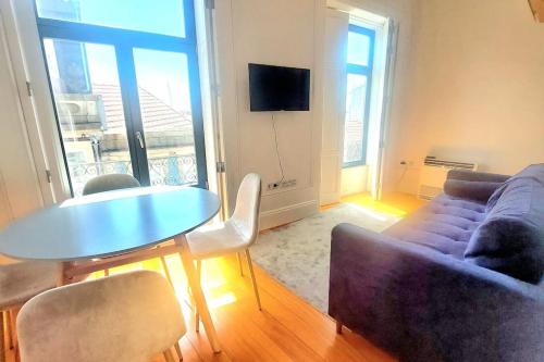 uma sala de estar com um sofá, uma mesa e cadeiras em Oporto City View - Wow Duplex no Porto