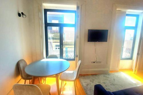 um quarto com uma mesa e cadeiras e uma televisão em Oporto City View - Wow Duplex no Porto