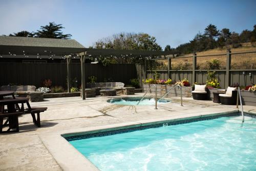 a swimming pool in a backyard with a table and chairs at Sea Otter Inn in Cambria