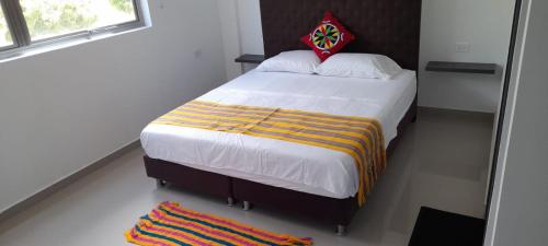 a bedroom with a large bed with a colorful blanket at SALINAS PLAZA HOTEL in Manaure