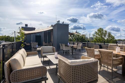 a patio with tables and chairs on a roof at Grimm´s Berlin Potsdam in Teltow