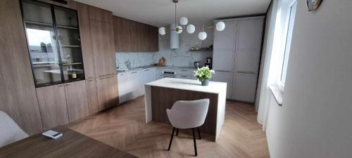 a kitchen with a white counter and a chair in it at Timo Baltic View in Gdańsk