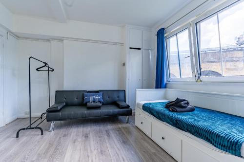 - une chambre avec un lit, une chaise et une fenêtre dans l'établissement Bright 1 Bed Flat near London Bridge, à Londres