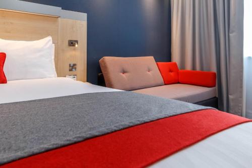 a hotel room with a bed and a couch at Holiday Inn Express Walsall M6, J10 by IHG in Walsall