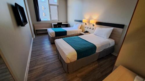 a hotel room with two beds and a flat screen tv at Hotel Diego de Almagro Calama Express in Calama
