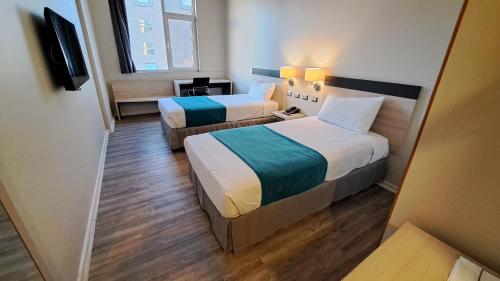 a hotel room with two beds and a television at Hotel Diego de Almagro Calama Express in Calama