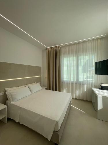Un dormitorio con una gran cama blanca y una ventana en Room Corso 219, en Montesilvano