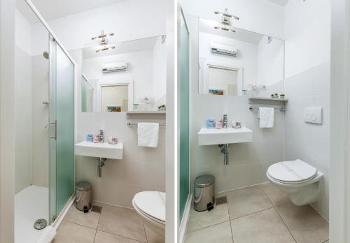 a bathroom with a toilet and two sinks and a shower at Boutique Suites Joyce in Pula