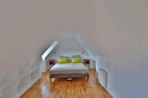 1 dormitorio con 1 cama con 2 almohadas amarillas en Gîte Louannec - Ty Bleiz en Louannec