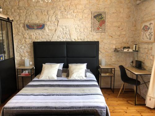 a bedroom with a bed and a table and a chair at Saint James House in Pons