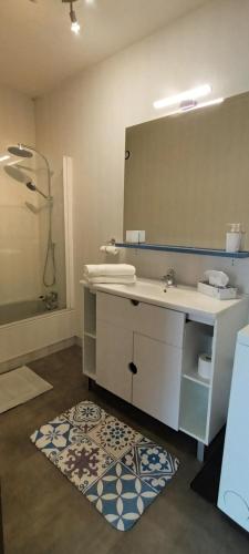 y baño con lavabo, espejo y alfombra. en Centre, Soulages, Amphithéâtre - clim balcon parking, en Rodez
