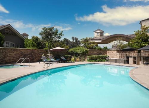 a swimming pool in a yard with a building in the background at West Inn & Suites in Carlsbad
