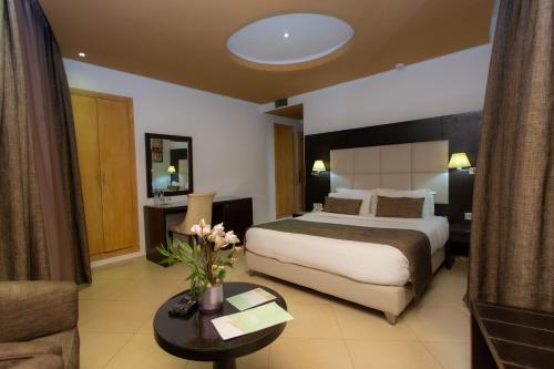 a large hotel room with a bed and a couch at Malak Hotel in Rabat