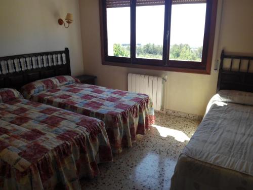 a bedroom with two beds and a window at Rincón De Pepe in El Castell de Guadalest