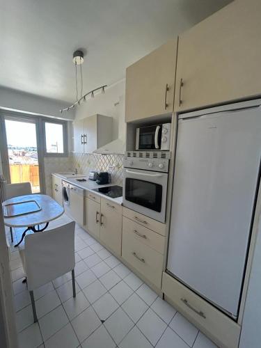une cuisine avec un réfrigérateur et une table à l'intérieur dans l'établissement Cannes Satellite, à Cannes