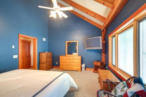a bedroom with blue walls and a bed and a tv at Waterfront Lake Champlain Home with Hot Tub and Sauna! in Melville Landing