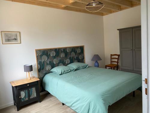 1 dormitorio con 1 cama verde con cabecero en La cabane du banc José, en Le Rozel