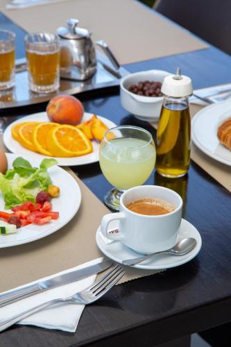 a table with plates of food and a cup of coffee at Malak Hotel in Rabat