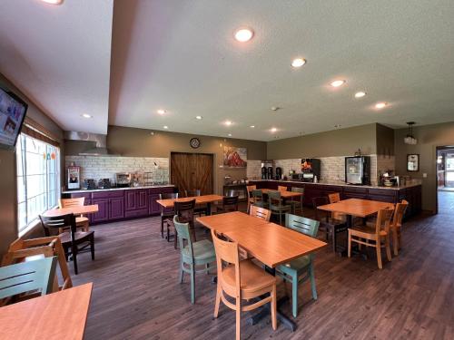 a restaurant with wooden tables and chairs and a kitchen at Country Inn Walker in Walker