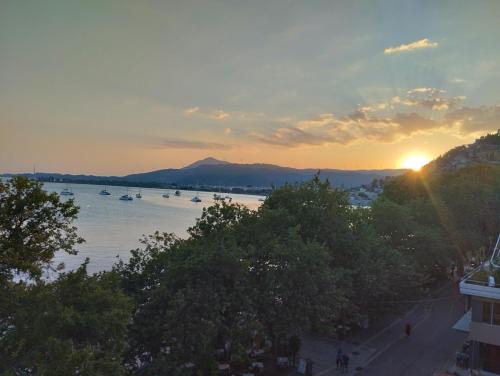 a sunset over a river with boats in the water at Πέτρινο στη θάλασσα in Nafpaktos