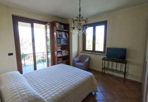 a bedroom with a bed and a tv and windows at Lavanda - Villa Rita in Gualdo Cattaneo