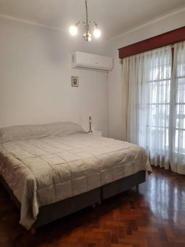 1 dormitorio con 1 cama en una habitación blanca en Amplio dpto. Peatonal Mendoza en Mendoza