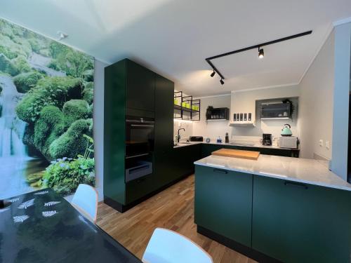 a kitchen with green cabinets and a large painting on the wall at Horten center in Horten