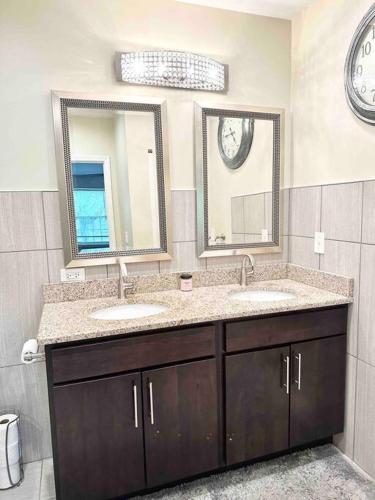 a bathroom with two sinks and two mirrors at Beautifully Renovated House 10 mins from Downtown in Chicago