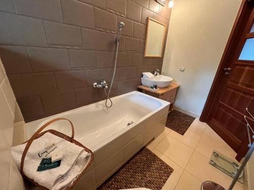 a bathroom with a bath tub and a sink at Villa 24B in Pobierowo