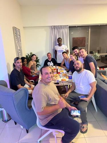 un grupo de personas sentadas alrededor de una mesa en Robin Beach Hostel JBR en Dubái