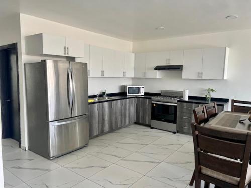 a kitchen with a stainless steel refrigerator and a table at DEPARTAMENTOS ARTICULO 123 - departamento #1 in Tijuana