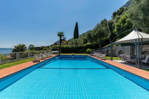 une piscine avec des chaises et un gazebo dans l'établissement Villa Aurora- Villa esclusiva con piscina e splendida vista lago, à Gargnano