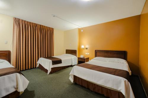 een hotelkamer met 2 bedden en een raam bij Cesar´s Hotel La Merced in Trujillo