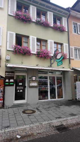 ein Laden mit Blumen an der Seite eines Gebäudes in der Unterkunft Schwabenstuben Doppelzimmer in Meersburg