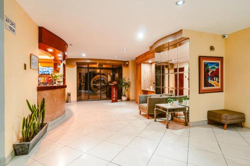 a lobby of a hospital with a couch and a table at Cesar´s Hotel La Merced in Trujillo