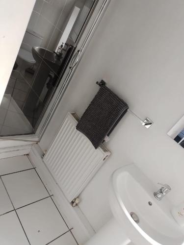 a white bathroom with a sink and a bath tub at En Suite room with kitchen facilities in Nottingham