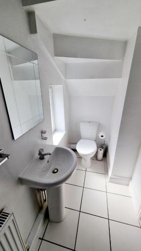 a white bathroom with a sink and a toilet at En Suite room with kitchen facilities in Nottingham