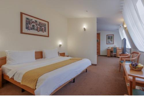 Un pat sau paturi într-o cameră la Dom Hotel Classic