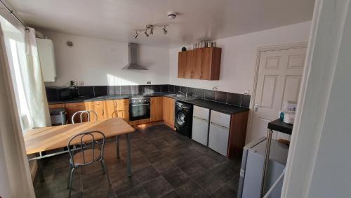 a kitchen with wooden cabinets and a table with chairs at En suite room with kitchen facilities in Nottingham