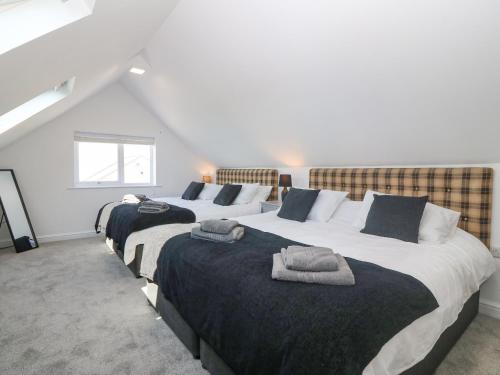 a row of three beds in a room at Glanffraw in Aberffraw